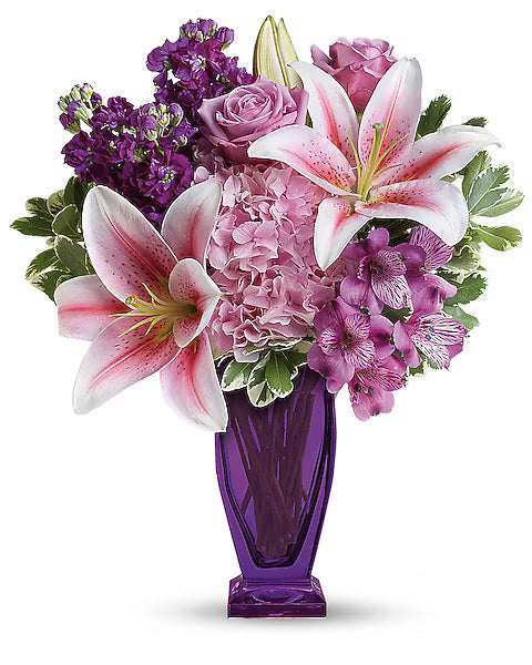 “Pink roses and green foliage bouquet in transparent vase